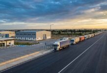 EDITO : Economie sous perfusion mondiale, entre illusion de résilience et dépendance stratégique Photographie éditoriale de haute qualité, prise par drone au crépuscule (heure dorée). La composition en plongée montre un poste frontière tunisien modernisé et sécurisé, symbolisant la volonté de transformation en hub économique.