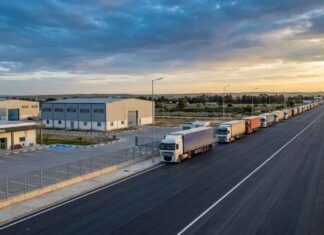 EDITO : Economie sous perfusion mondiale, entre illusion de résilience et dépendance stratégique Photographie éditoriale de haute qualité, prise par drone au crépuscule (heure dorée). La composition en plongée montre un poste frontière tunisien modernisé et sécurisé, symbolisant la volonté de transformation en hub économique.